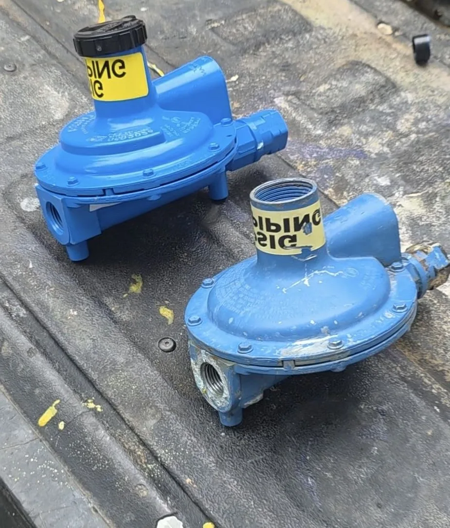 Old faded and new glossy propane regulators side by side in the truck bed after a Westminster, MD replacement